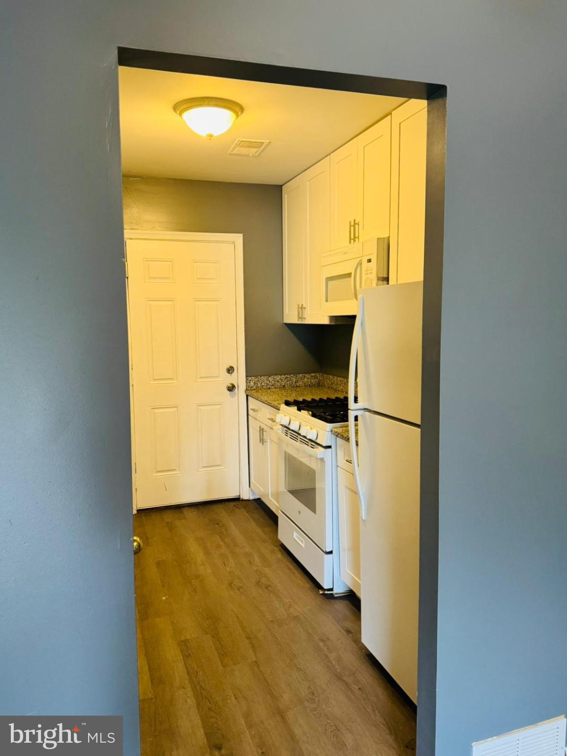 7719 Normandy Road Landover, MD 20785 - Photo 9 of 18 a kitchen with a stove and white cabinets