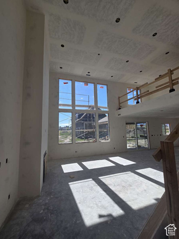 338 West 3400 South Logan, UT 84321 - Photo 18 of 40 Expansive, high-ceilinged room featuring a multi-pane window wall, recessed lighting, a built-in fireplace, and a sliding glass door