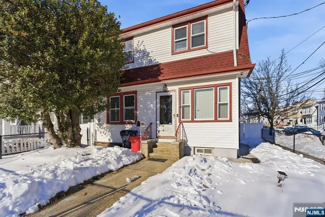 a front view of a house with a yard covered in snow