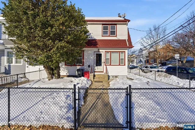 a view of a white house with wooden fence
