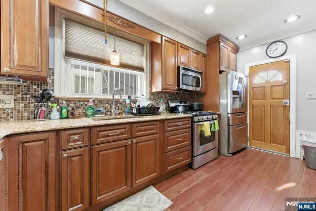 a kitchen with stainless steel appliances granite countertop a refrigerator and a stove top oven