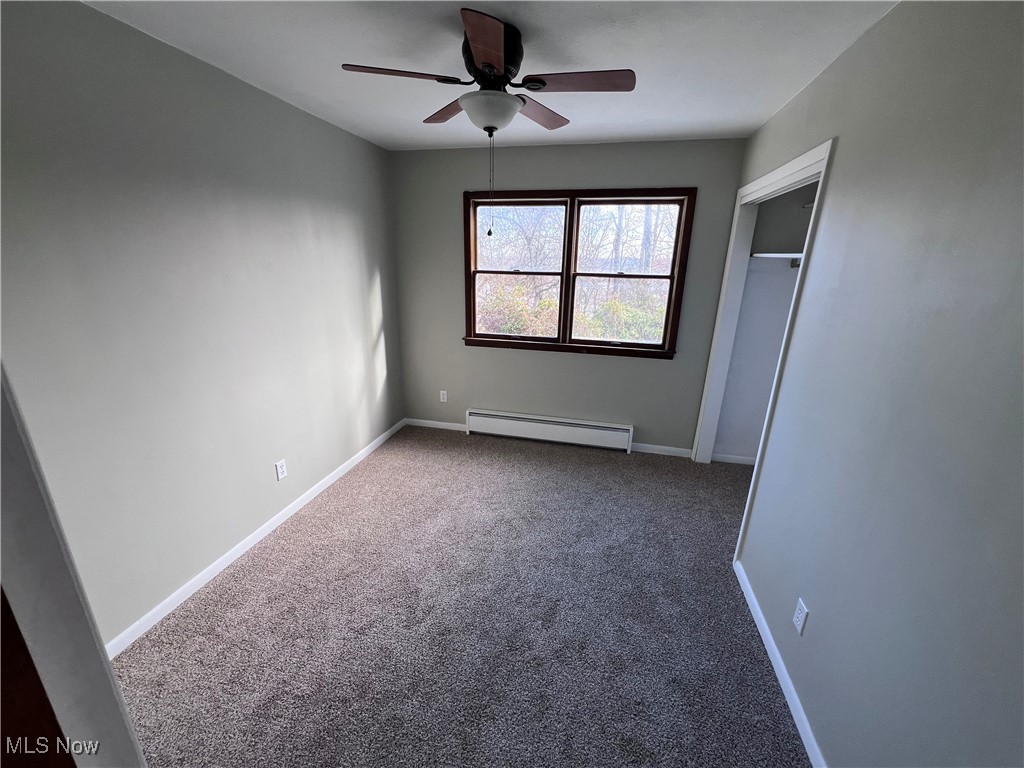 56376 Jordan Run Road Bellaire, OH 43906 - Photo 23 of 45 Unfurnished bedroom with ceiling fan, a closet, carpet floors, and a baseboard heating unit