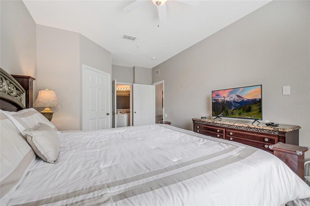 2817 Almaton Loop, Unit 301 Kissimmee, FL 34747 - Photo 19 of 51 a bedroom with a bed and a flat screen tv