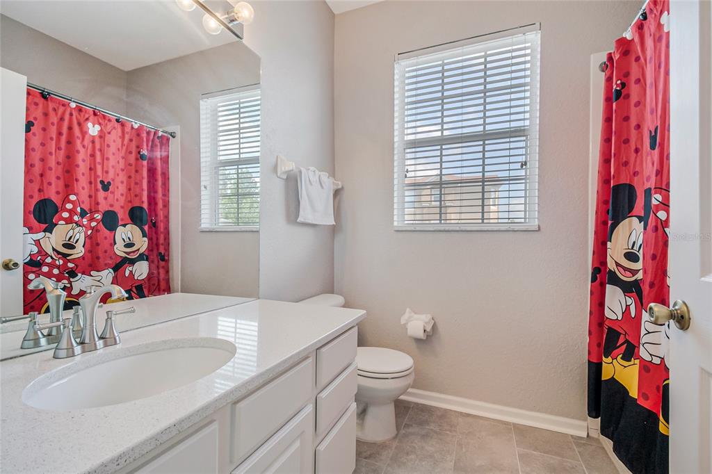 2817 Almaton Loop, Unit 301 Kissimmee, FL 34747 - Photo 26 of 51 a bathroom with a sink mirror vanity and toilet