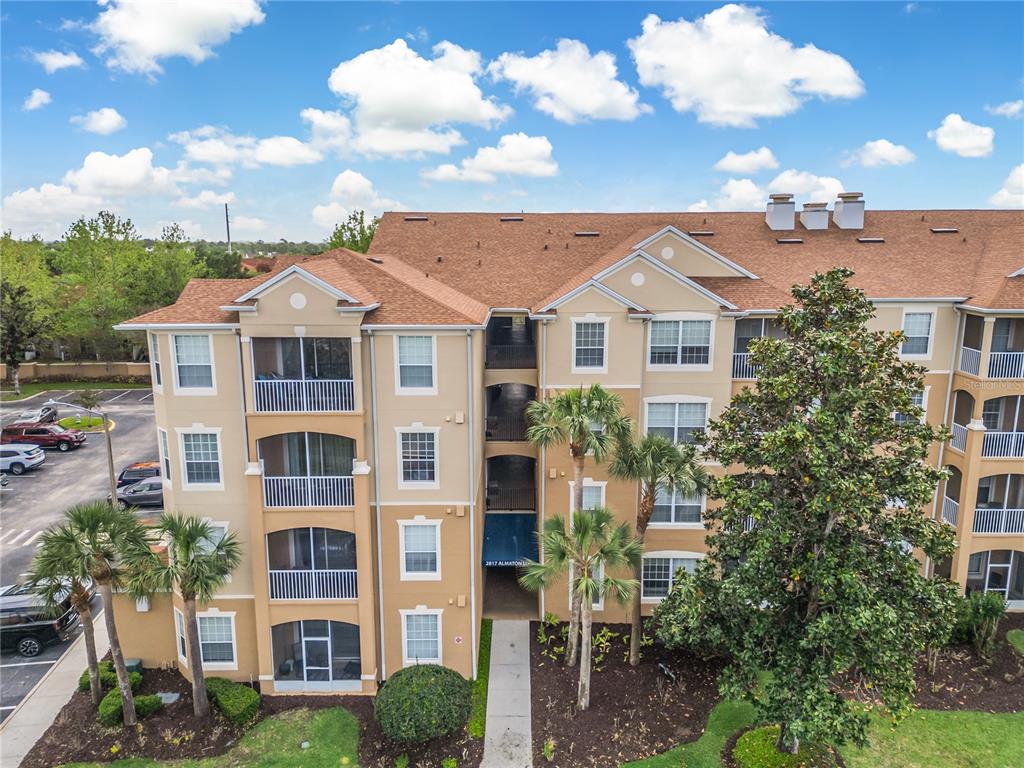 2817 Almaton Loop, Unit 301 Kissimmee, FL 34747 - Photo 38 of 51 a front view of a residential apartment building with yard and entryway