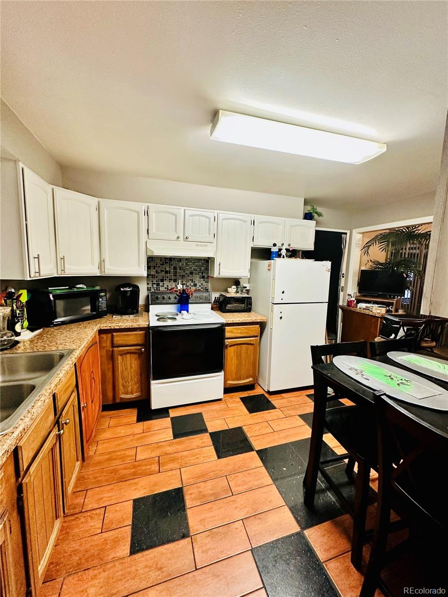 662 South Tejon Street Denver, CO 80223 - Photo 16 of 19 a kitchen with stainless steel appliances kitchen island granite countertop a refrigerator and sink