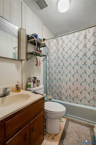 a bathroom with a sink a toilet and shower curtain