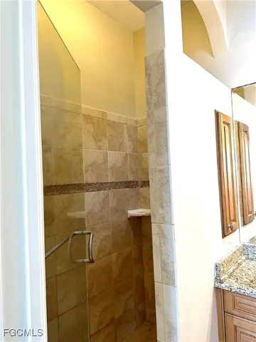 a bathroom with a granite countertop shower and a sink
