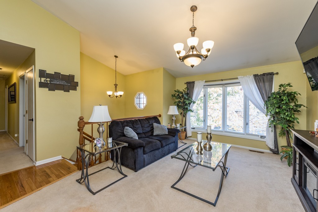 724 Roberts Road Winthrop Harbor, IL 60096 - Photo 9 of 31 a living room with furniture a chandelier and a window