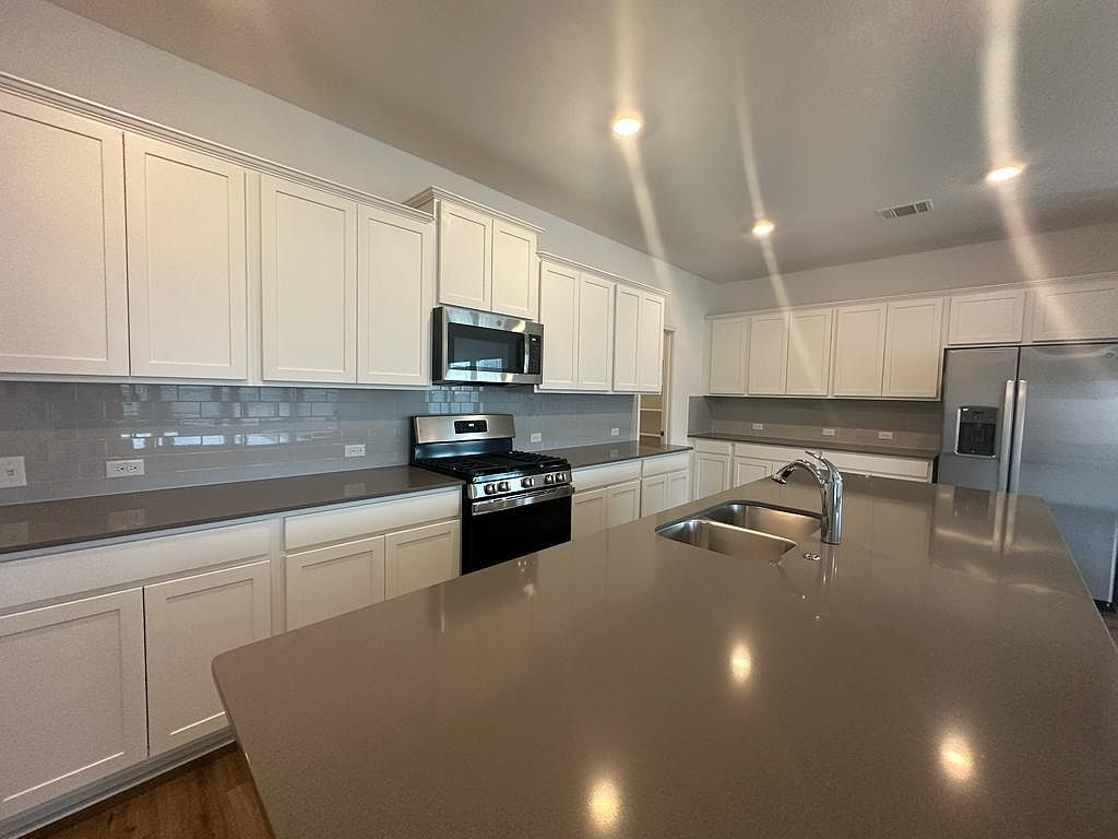 160 River Rise Road Kyle, TX 78640 - Photo 23 of 35 Expansive kitchen island with an undermount double basin sink and chrome faucet