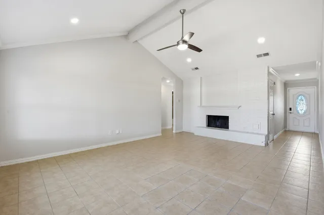 an empty room with fireplace and windows