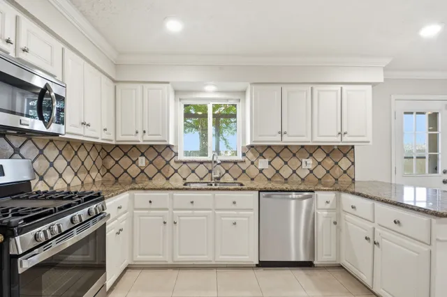 a kitchen with granite countertop white cabinets and white appliances