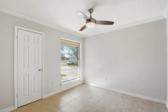 an empty room with a ceiling fan and a window