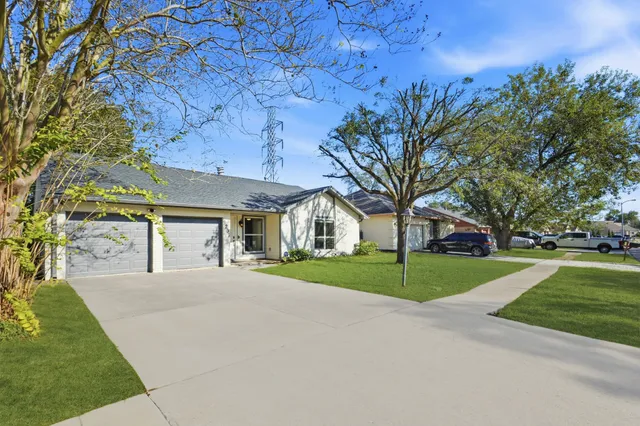 a front view of a house with a yard and trees