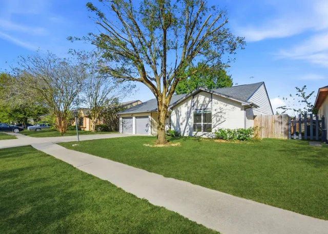 a tree in front of a white house