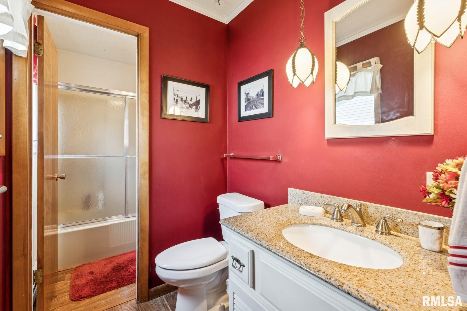 1825 5th Avenue South Clinton, IA 52732 - Photo 17 of 34 a bathroom with a granite countertop toilet a sink and a mirror