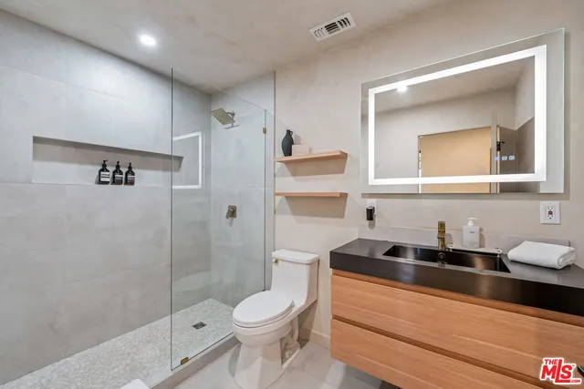 a bathroom with a sink a toilet and a shower