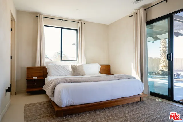 a bedroom with a bed and large window