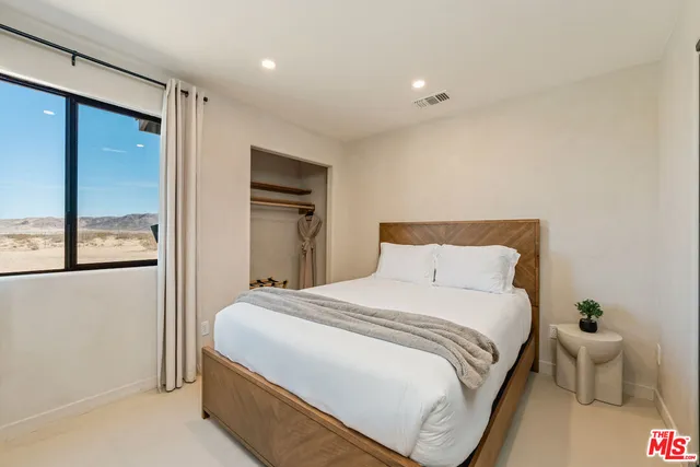 a bedroom with a bed and a potted plant