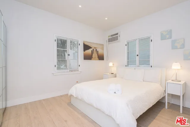 a bedroom with a bed cabinet and mirror