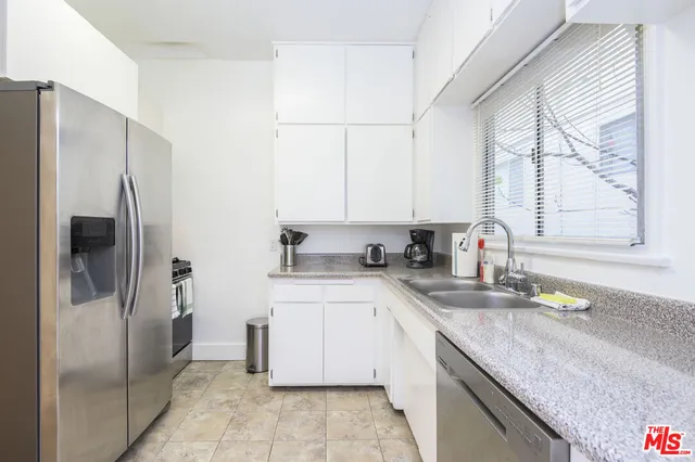 a kitchen with a sink a refrigerator and cabinets