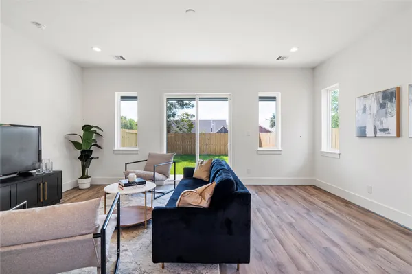 a living room with furniture a window and a flat screen tv