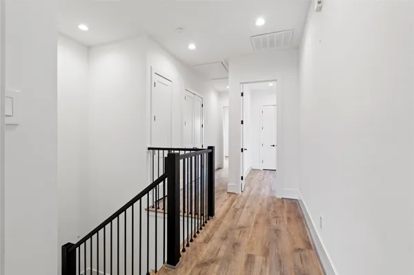 a view of a hallway with wooden floor