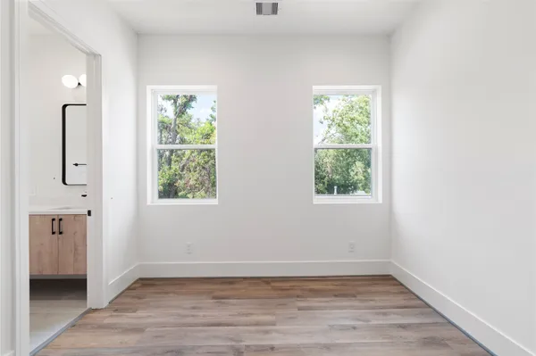 an empty room with window and wooden floor