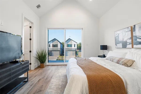 a bedroom with a bed and a flat tv screen on dresser