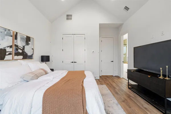 a bedroom with a bed and a flat screen tv