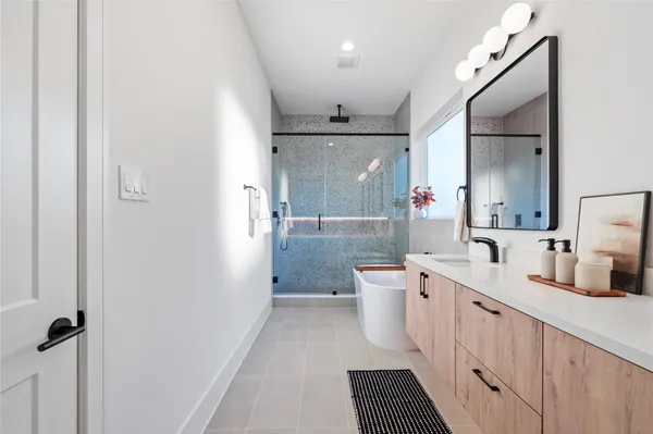a bathroom with a double vanity sink toilet mirror and shower