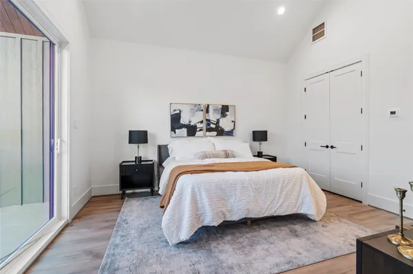 a bedroom with a bed and a potted plant on dresser