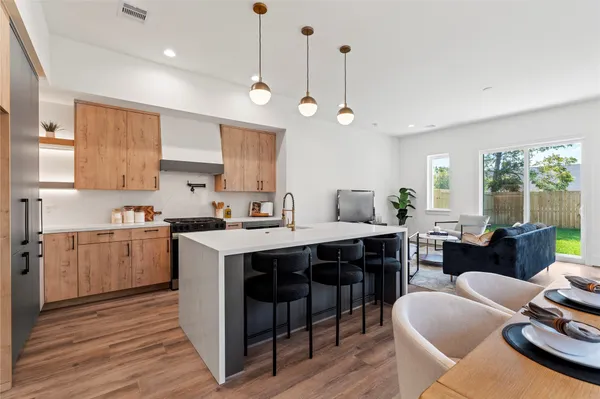a large kitchen with kitchen island a island a sink a stove and a living room view
