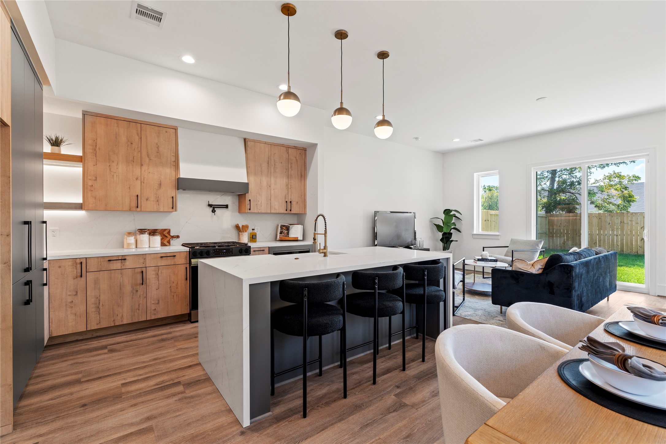 4218 Nichols Street Houston, TX 77020 - Photo 4 of 45 a large kitchen with kitchen island a island a sink a stove and a living room view