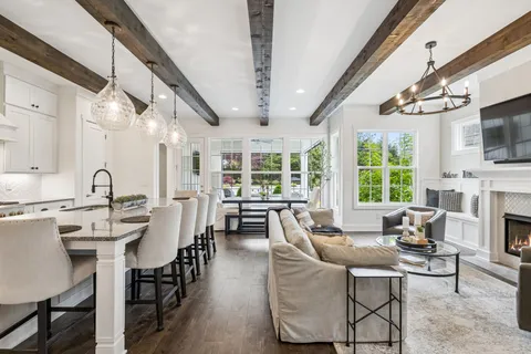 a kitchen with stainless steel appliances kitchen island granite countertop a table chairs stove and white cabinets