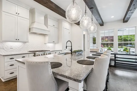 a spacious bathroom with a granite countertop sink a mirror and a bathtub