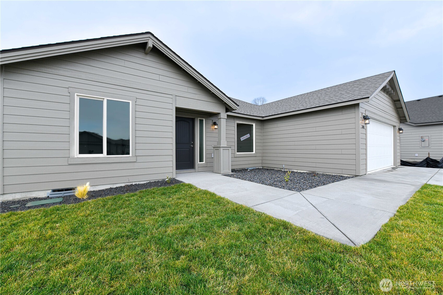 308 North Sandy Loop Moses Lake, WA 98837 - Photo 3 of 18 a front view of a house with a yard and garage
