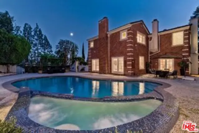 a view of a house with swimming pool and sitting area