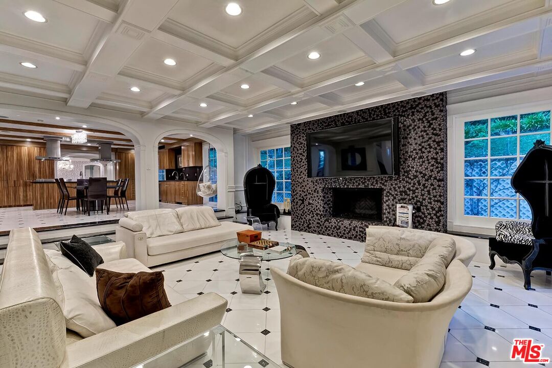 725 North Faring Road Los Angeles, CA 90077 - Photo 15 of 56 a living room with furniture a large window and a fireplace