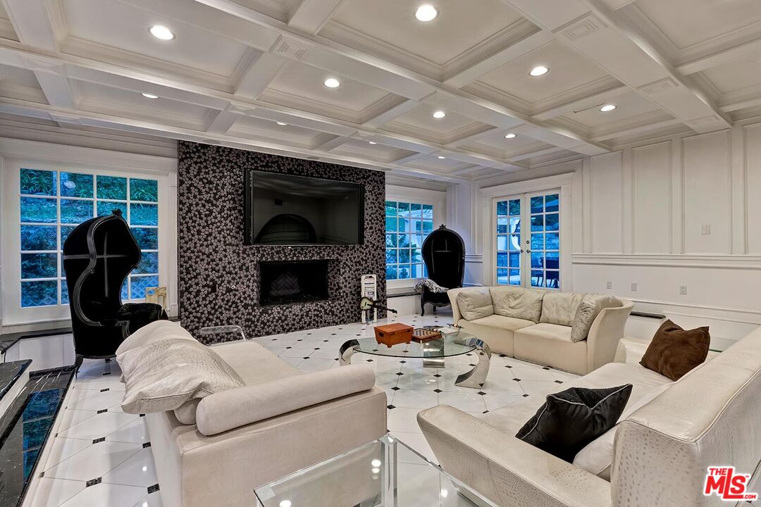 725 North Faring Road Los Angeles, CA 90077 - Photo 16 of 56 a living room with furniture a fireplace and a flat screen tv