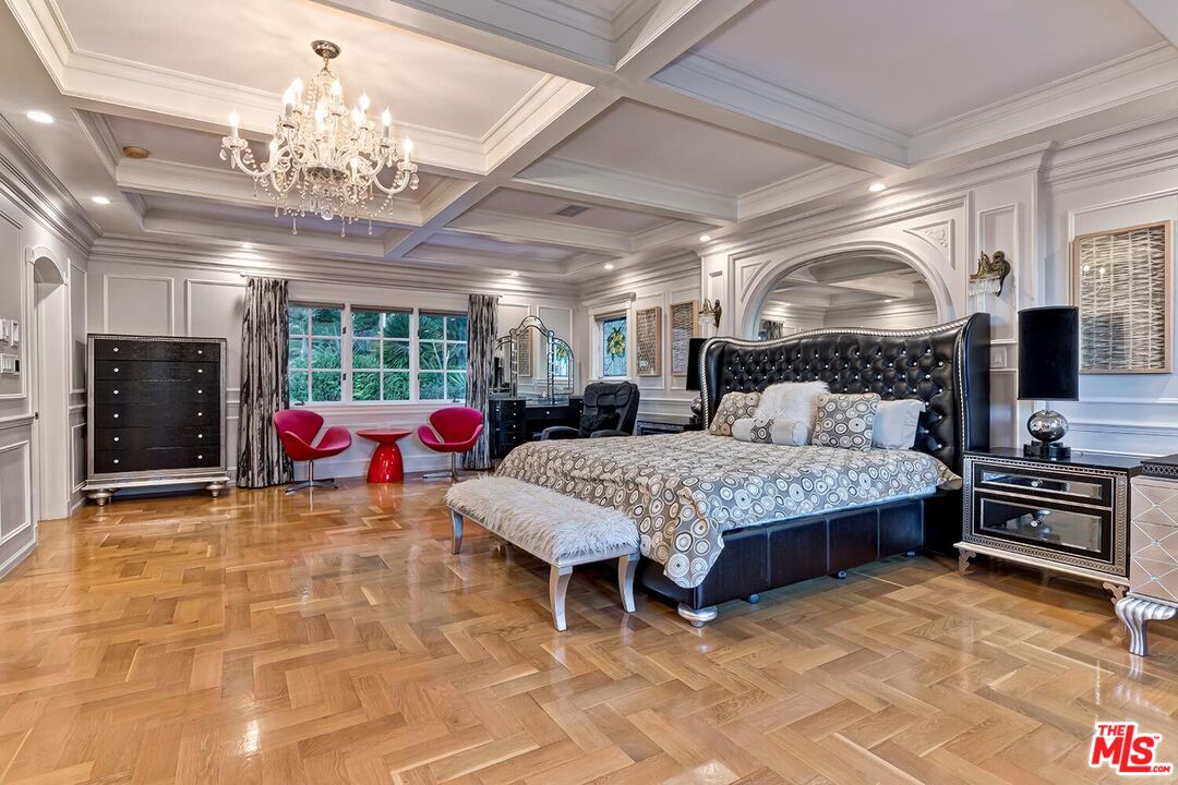 725 North Faring Road Los Angeles, CA 90077 - Photo 37 of 56 a bedroom with a bed a chandelier and flat screen tv