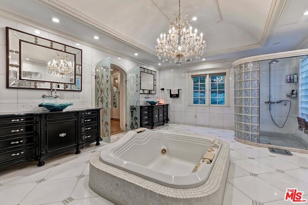 725 North Faring Road Los Angeles, CA 90077 - Photo 38 of 56 a spacious bathroom with a granite countertop sink a mirror a bathtub and shower