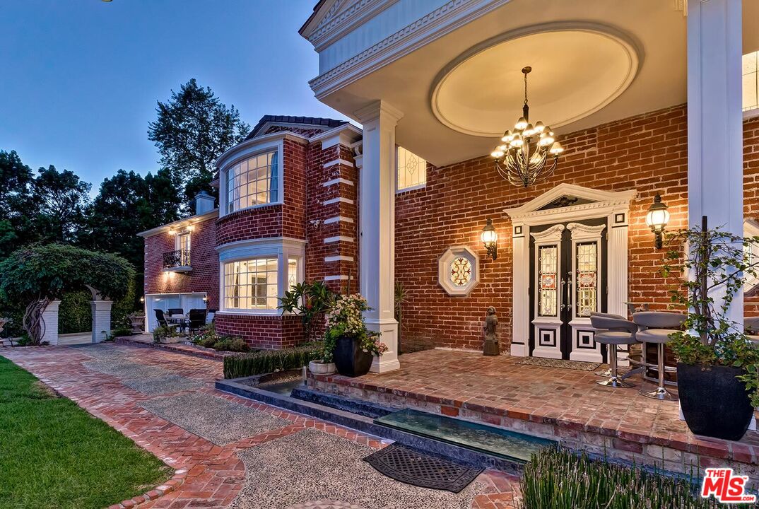 725 North Faring Road Los Angeles, CA 90077 - Photo 7 of 56 a front view of a house with a porch and a fountain