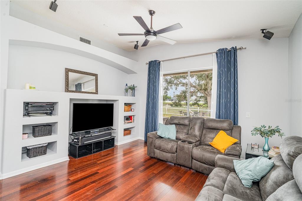 13612 Sigler Street Riverview, FL 33579 - Photo 6 of 31 a living room with furniture a flat screen tv and a floor to ceiling window