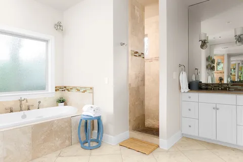 a bathroom with a tub sink and mirror