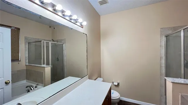 a view of a big room with wooden floor and a ceiling fan