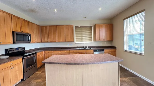 a kitchen with stainless steel appliances granite countertop refrigerator sink and cabinets