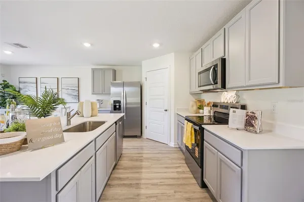 a kitchen with sink a microwave and cabinets
