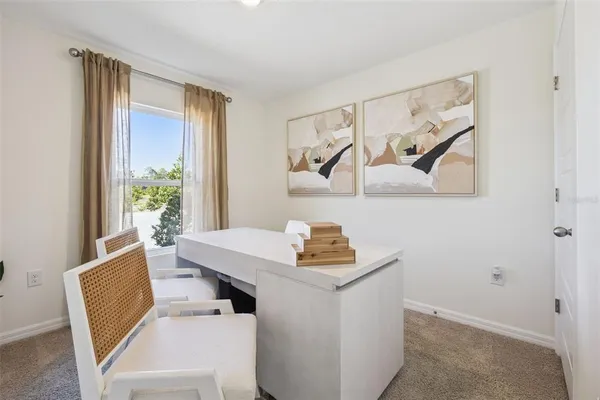 a view of a workspace with furniture and window