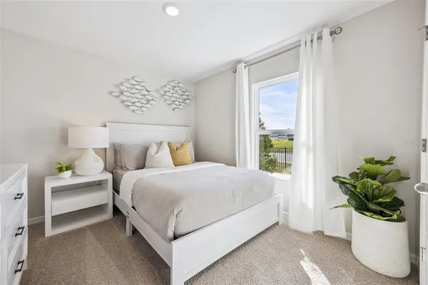 a bedroom with a bed and a potted plant